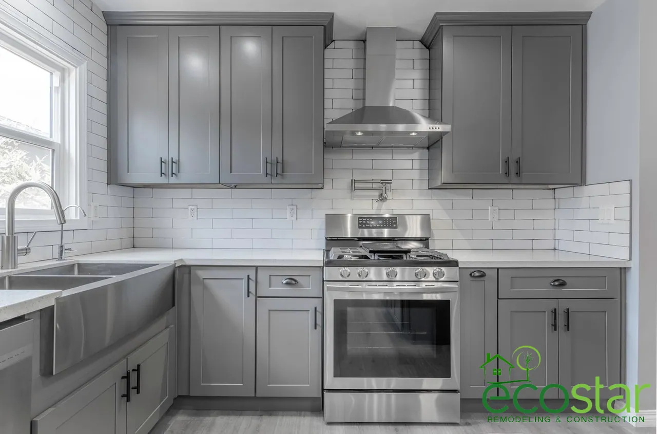 Gray shaker cabinets with a white subway tile backsplash and a farmhouse sink, by EcoStar Remodeling & Construction