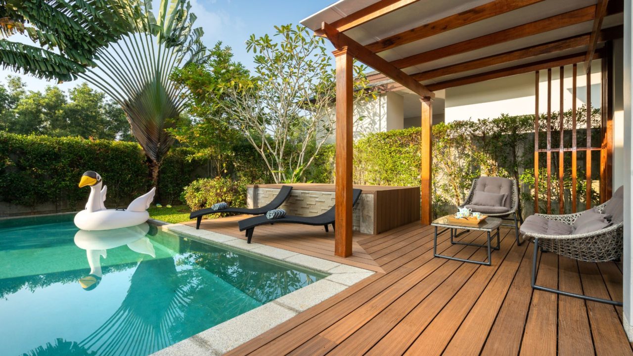 Wood pool deck with a covered patio and lounge seating